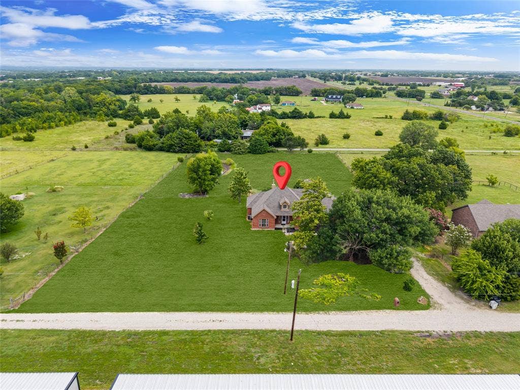 18723 Sims Lane, Nevada, TX 75173 Expansive green landscape surrounding a brick residence with a dormer and mature trees