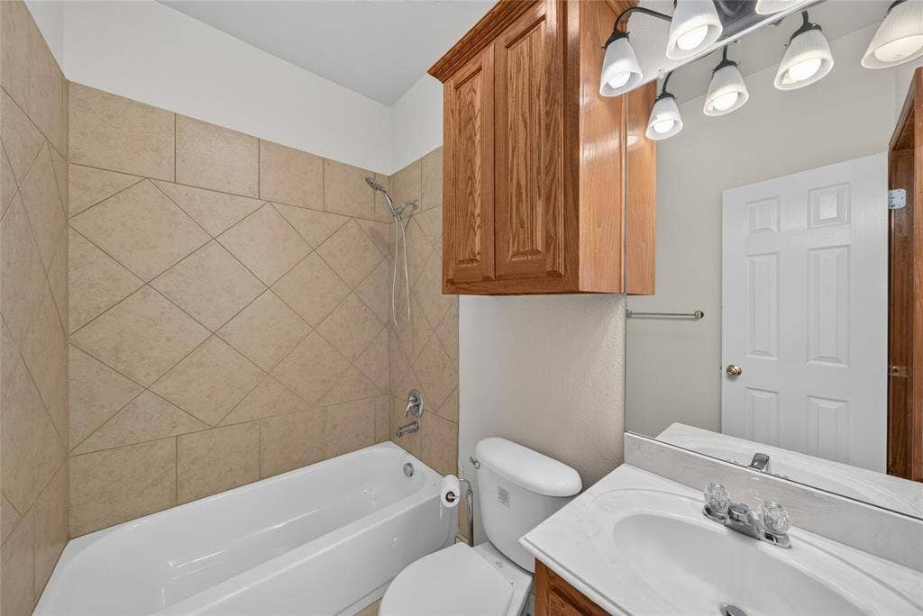 18723 Sims Lane, Nevada, TX 75173 Bathroom featuring a white bathtub, ceramic tile surround with diagonal pattern, and a chrome shower head