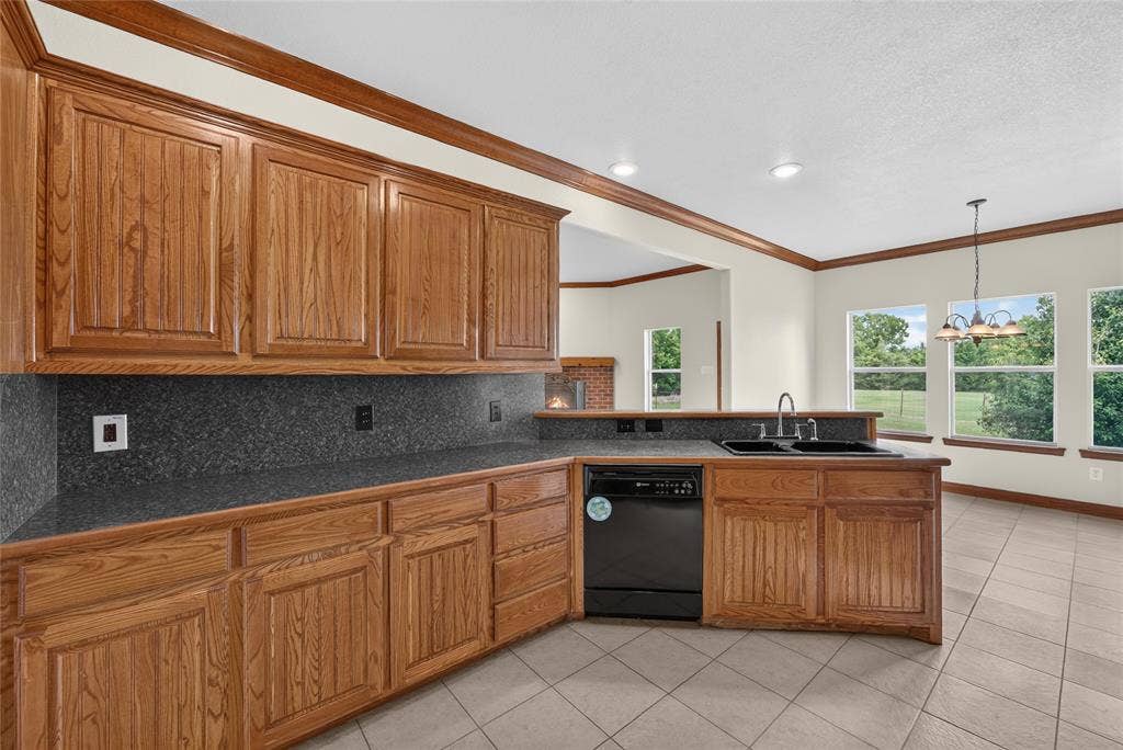 18723 Sims Lane, Nevada, TX 75173 Kitchen featuring wood cabinetry, dark countertops, built-in dishwasher, and a double basin sink