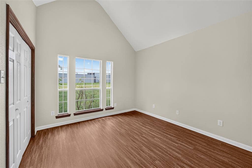 18723 Sims Lane, Nevada, TX 75173 Vaulted ceiling room featuring wood-finish flooring, light neutral wall paint, and white trim