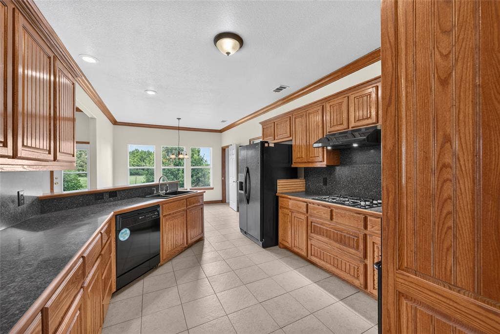 18723 Sims Lane, Nevada, TX 75173 Expansive kitchen featuring wood cabinetry, stone countertops, and tile flooring
