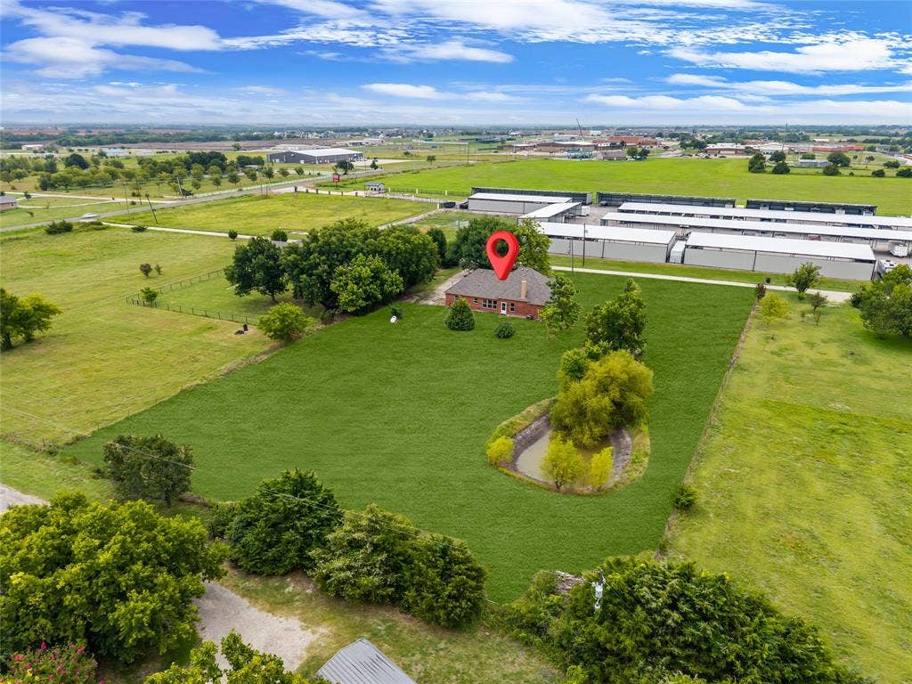 18723 Sims Lane, Nevada, TX 75173 Expansive property featuring a single-story brick residence with a gabled roof, surrounded by extensive green lawn