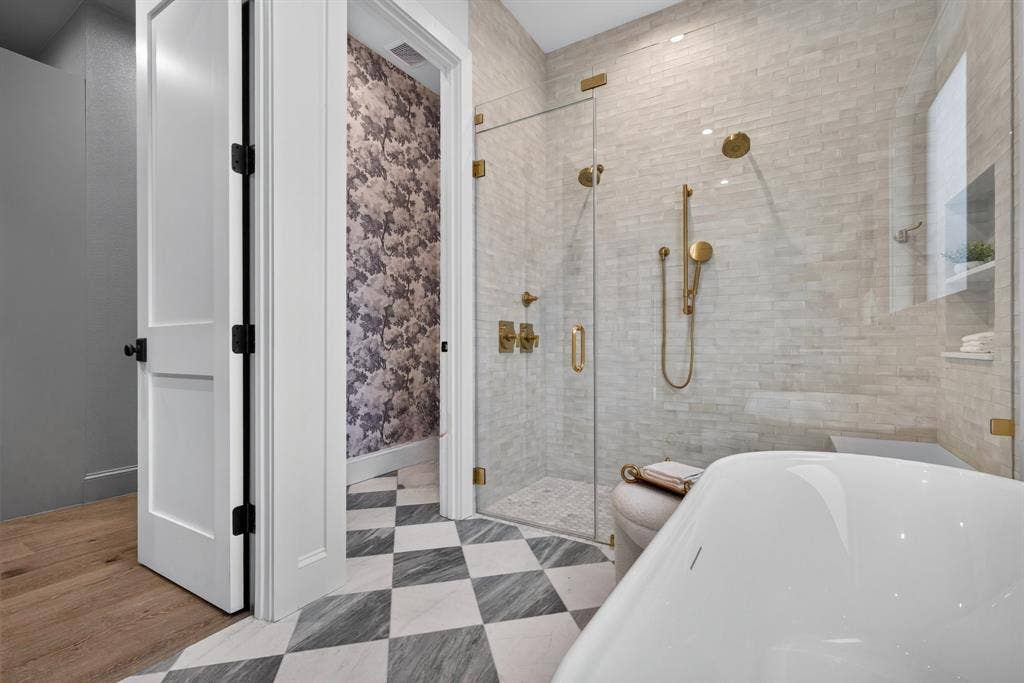 6817 Blessing Drive, Dallas, TX 75214 Bathroom featuring a walk-in glass shower enclosure with brass fixtures, light-toned subway tile, a freestanding soaking tub, and checkerboard floor tiling