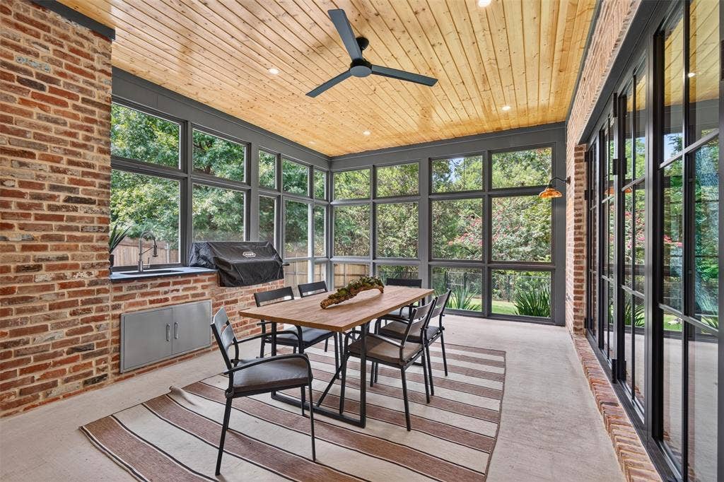6817 Blessing Drive, Dallas, TX 75214 Screened porch featuring exposed brick walls, a wood-plank ceiling with recessed lighting, and large windows