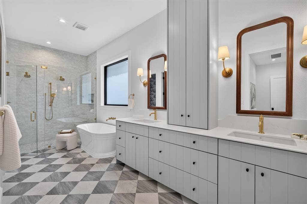 6817 Blessing Drive, Dallas, TX 75214 Expansive bathroom featuring a standalone soaking tub and an oversized glass-enclosed shower with gold-tone fixtures