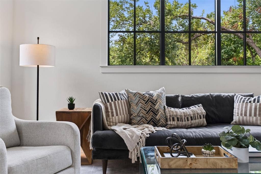 6817 Blessing Drive, Dallas, TX 75214 Spacious living area featuring a large picture window with black grid panes, white trim, and abundant natural light