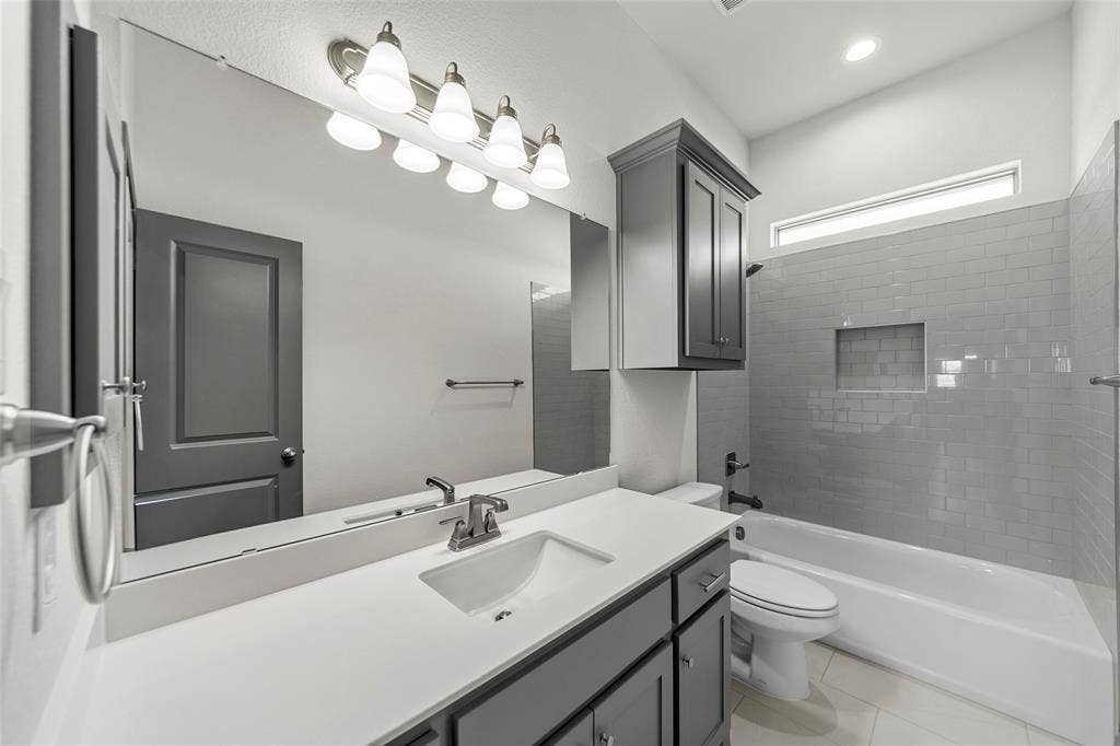 Full-width vanity mirror reflecting a gray paneled door