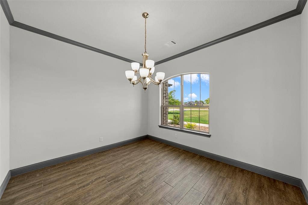 Room featuring wood-look tile flooring, gray baseboards, and gray crown molding