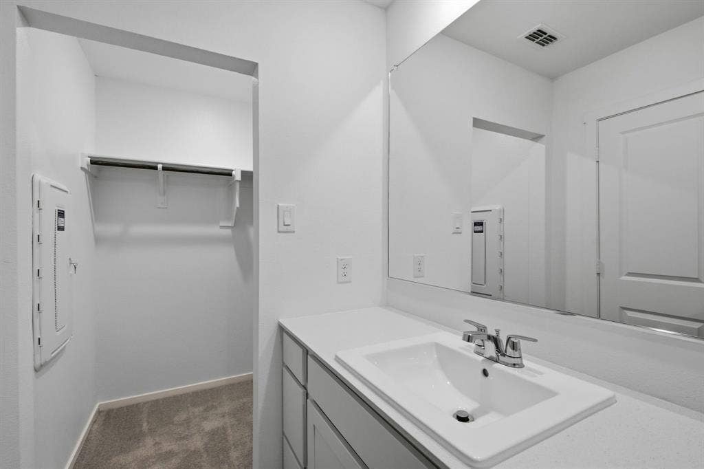 6307 Sandpiper Lane, Princeton, TX 75407 Bathroom vanity featuring an integrated rectangular sink, chrome faucet, and expansive wall-mounted mirror