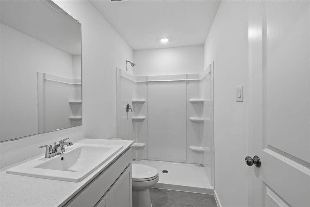 6307 Sandpiper Lane, Princeton, TX 75407 Bathroom featuring a single vanity with a white countertop and integrated sink, chrome faucet, and a large wall-mounted mirror