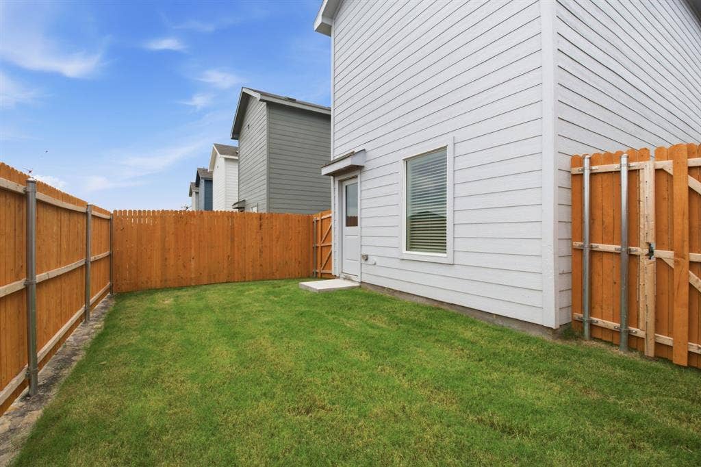 6307 Sandpiper Lane, Princeton, TX 75407 Private backyard featuring a manicured lawn, wood privacy fencing, and a side access gate
