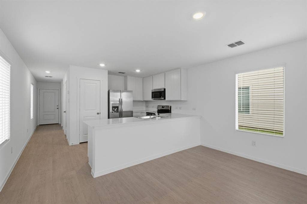 6307 Sandpiper Lane, Princeton, TX 75407 Open-concept living space featuring wood-finish flooring, recessed lighting, and a kitchen island with a light-toned countertop