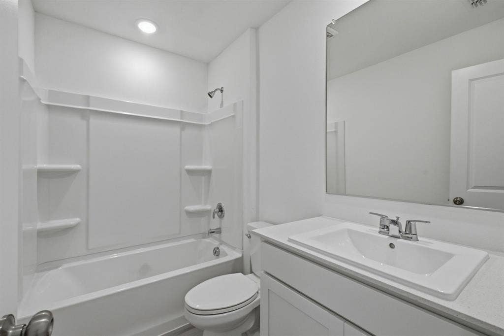 6307 Sandpiper Lane, Princeton, TX 75407 Bathroom featuring a white vanity with an integrated sink, silver-toned faucet, and a large wall-mounted mirror