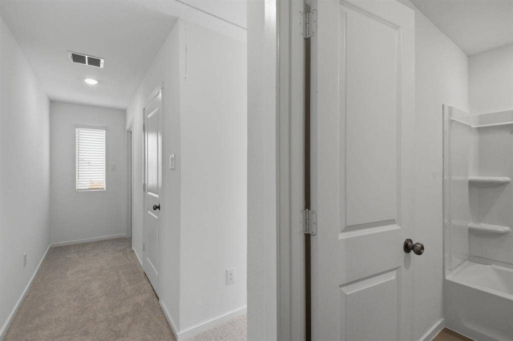 6307 Sandpiper Lane, Princeton, TX 75407 Carpeted hallway with a window featuring horizontal blinds