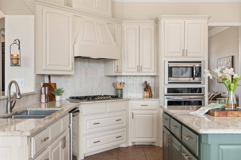 13425 Willow Creek Drive, Haslet, TX 76052 large island, peninsula seating, extensive cabinetry, double ovens, gas cooktop and a direct visual connection through the breakfast area to the backyard.