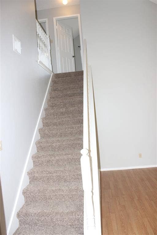285 Alex Drive, Coppell, TX 75019 Carpeted staircase with white balusters leading to an upper level with a paneled door