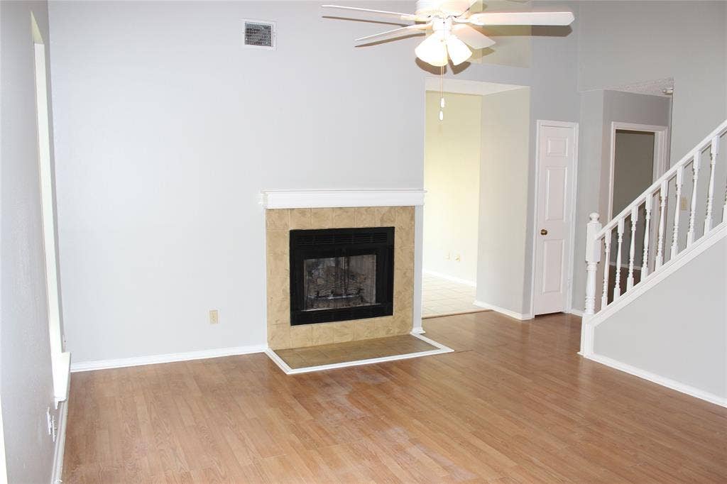 285 Alex Drive, Coppell, TX 75019 Living area featuring a fireplace with a tile surround and mantel, wood-finish flooring, and a ceiling fan
