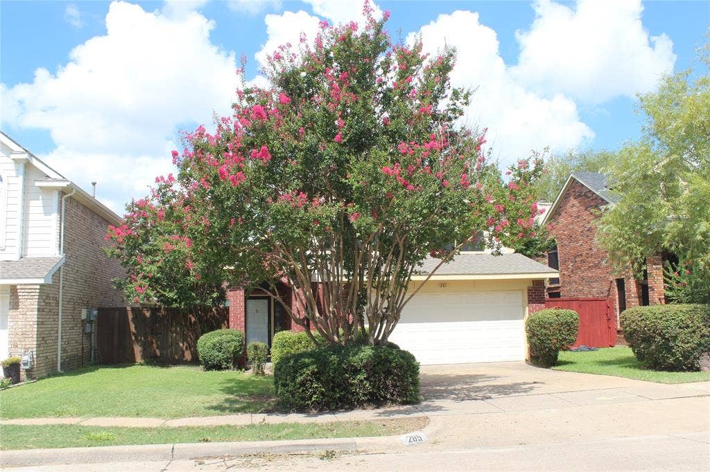 285 Alex Drive, Coppell, TX 75019 Brick and siding exterior with a prominent flowering tree