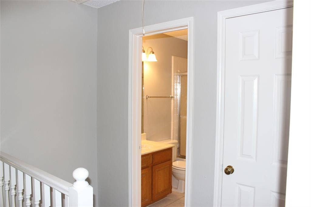 285 Alex Drive, Coppell, TX 75019 Full bathroom featuring a wood-finish vanity, white countertop, and glass-enclosed shower
