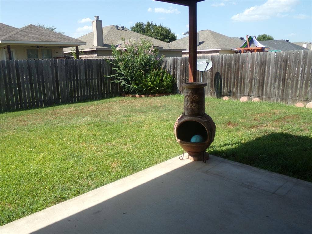 4708 Topaz Lane, Granbury, TX 76049 Expansive backyard featuring a lush lawn, privacy fencing, and a concrete patio pad
