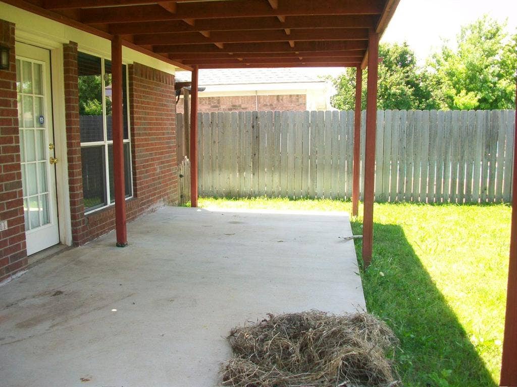 4708 Topaz Lane, Granbury, TX 76049 Covered concrete patio with wooden support beams and an exposed rafter ceiling