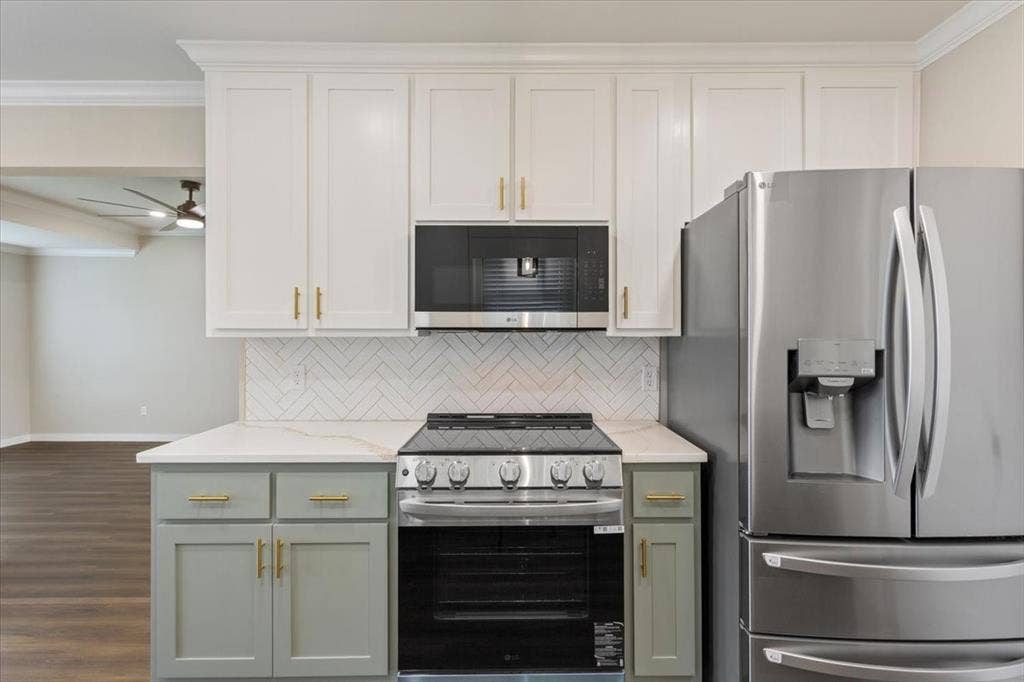 116 Boleman Drive, Hewitt, TX 76643 Modern kitchen featuring an LG stainless steel appliance package and white upper cabinetry with sage green lower cabinetry and gold-tone hardware