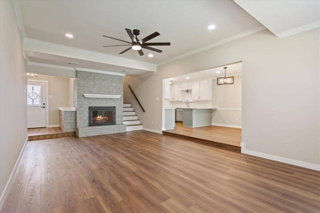 116 Boleman Drive, Hewitt, TX 76643 Spacious interior featuring a wood burning brick fireplace with glass doors, luxury vinyl plank wood-finish flooring, a contemporary ceiling fan, and recessed lighting