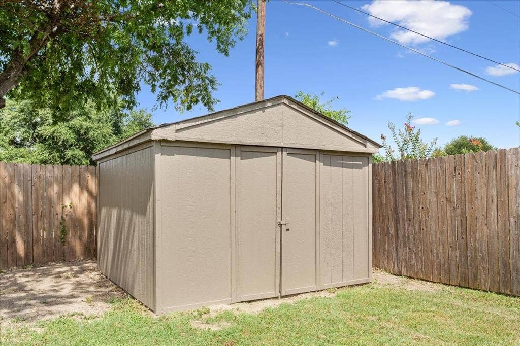 116 Boleman Drive, Hewitt, TX 76643 Recently painted storage shed with double doors, concrete floor, wood-paneled siding, and a surrounding wood fence