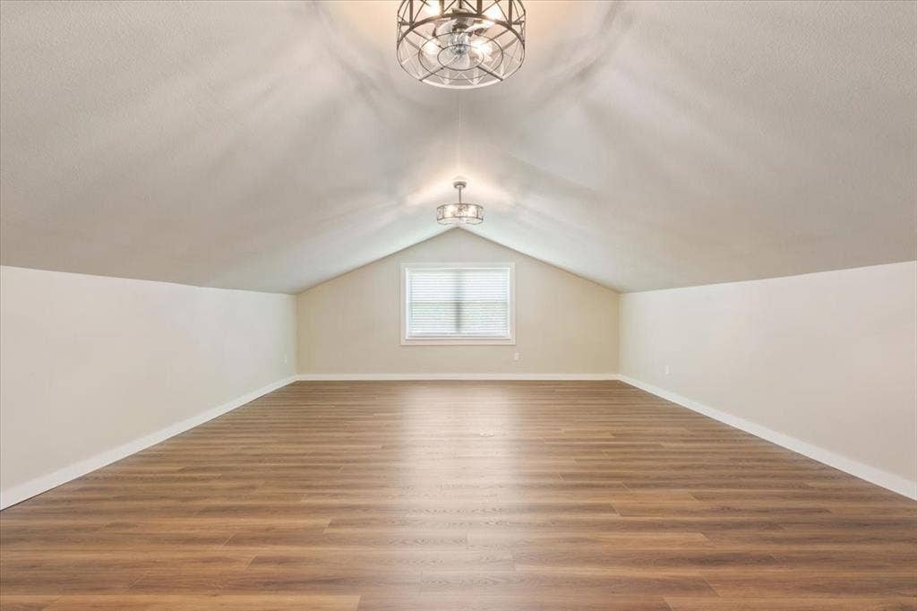 116 Boleman Drive, Hewitt, TX 76643 Spacious 4th bedroom / bonus room featuring LVP wood-finish flooring, a vaulted ceiling, a built-in window, and two ceiling-mounted decorative light fixtures with ceiling fans (mini)