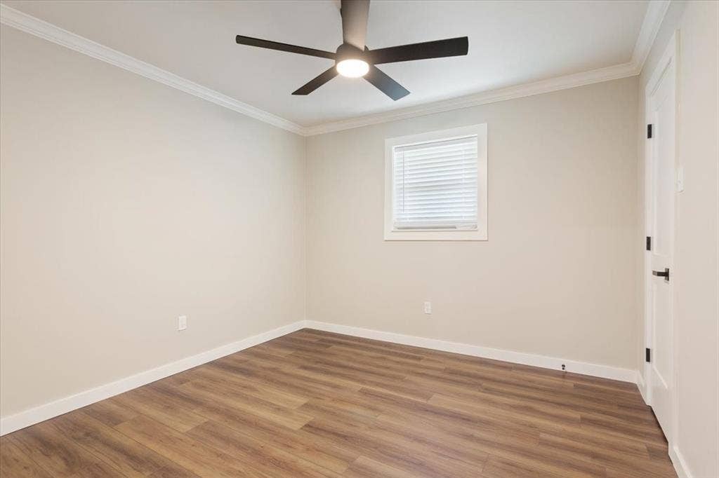 116 Boleman Drive, Hewitt, TX 76643 Spacious room featuring wood-finish flooring, a contemporary ceiling fan with integrated lighting, a white framed window with blinds, and clean crown molding