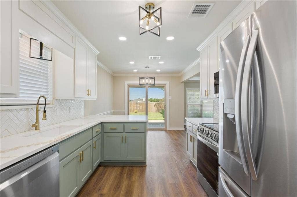 116 Boleman Drive, Hewitt, TX 76643 Kitchen featuring two-tone cabinetry with gold-tone hardware, white quartz countertops, herringbone tile backsplash, and LVP wood-finish flooring