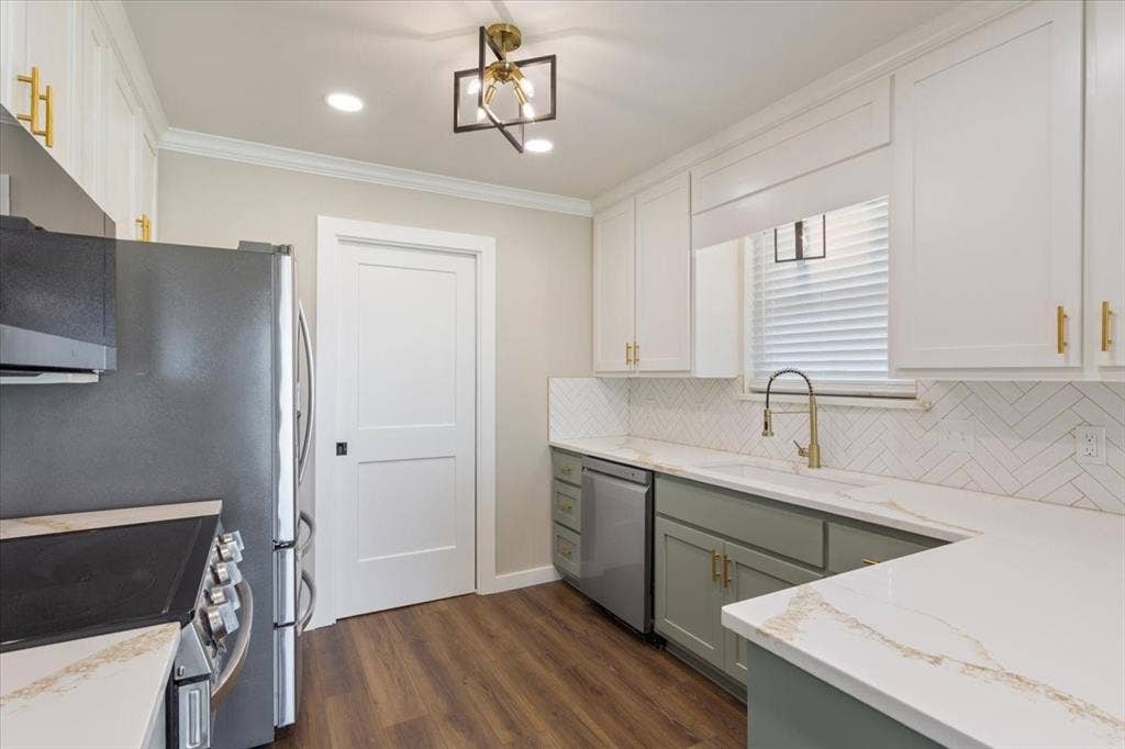 116 Boleman Drive, Hewitt, TX 76643 Kitchen featuring two-tone cabinetry with gold-tone hardware, white quartz countertops, stainless steel appliances, herringbone tile backsplash, and LVP wood-finish flooring