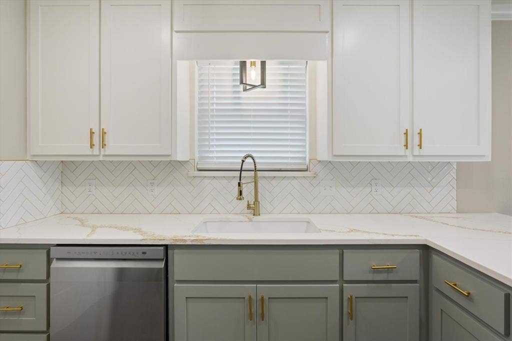 116 Boleman Drive, Hewitt, TX 76643 Kitchen featuring a large farm style sink with gooseneck faucet, quartz countertops, white herringbone tile backsplash, and two-tone cabinetry with gold-finish hardware