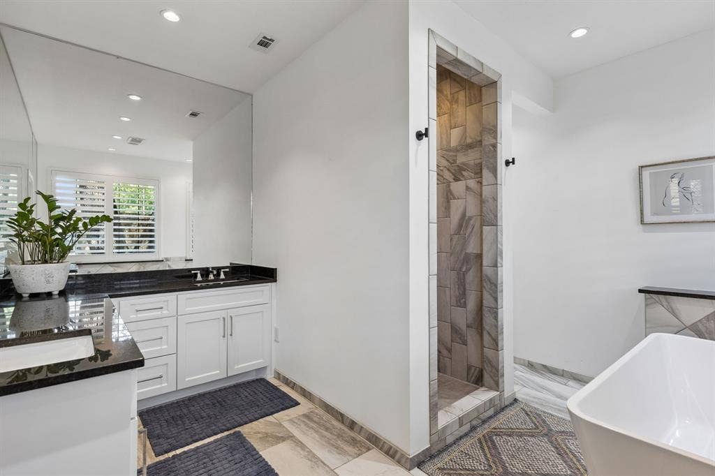6015 Shetland Drive, Dallas, TX 75230 The primary bath is serene and spa like with free-standing tub, walk-in shower and great natural light.