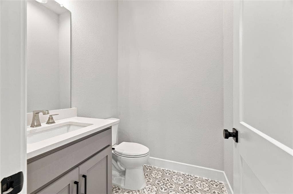 3820 Jacks Loop, Midlothian, TX 76065 Patterned floor tile, white vanity countertop, undermount sink, brushed nickel faucet, and gray vanity cabinetry