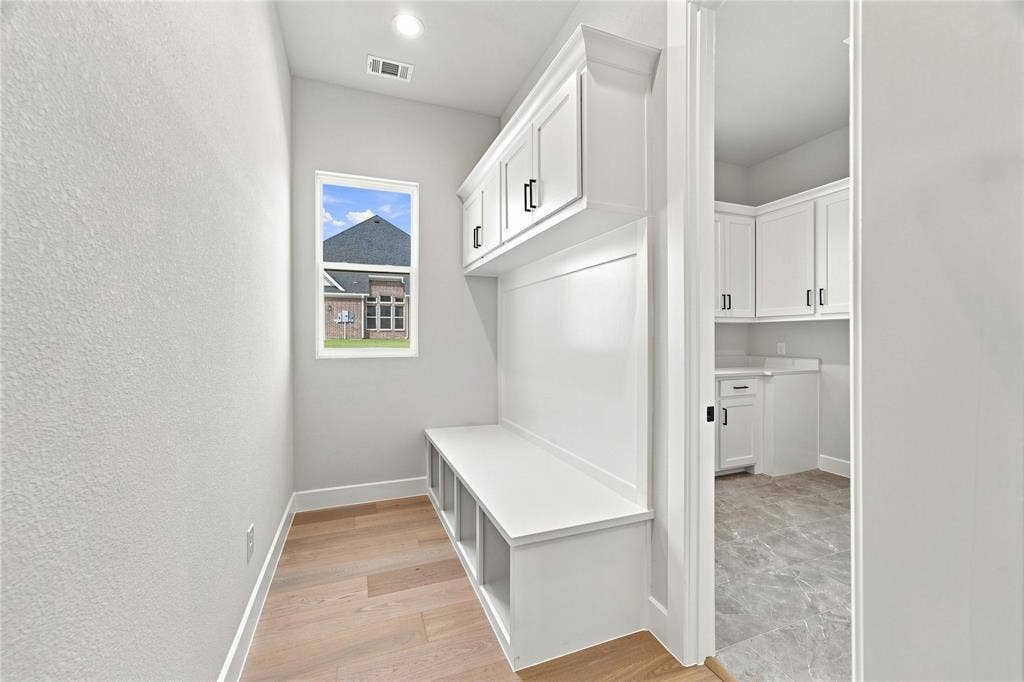 3820 Jacks Loop, Midlothian, TX 76065 Built-in bench with cubby storage, upper cabinetry with black hardware, and wood-finish flooring