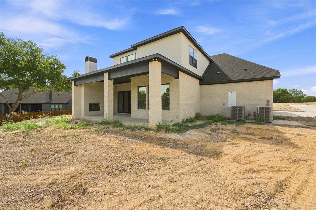 3820 Jacks Loop, Midlothian, TX 76065 Covered patio with a built-in outdoor fireplace, light-colored brick exterior, dark roof, and multiple windows