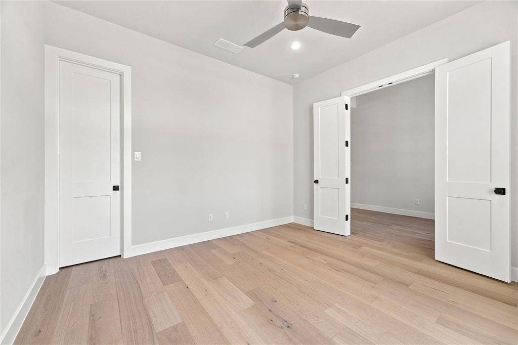 3820 Jacks Loop, Midlothian, TX 76065 Light wood-finish flooring throughout, bright white walls, contemporary ceiling fan with integrated lighting, recessed ceiling light, and white paneled doors with matte black hardware
