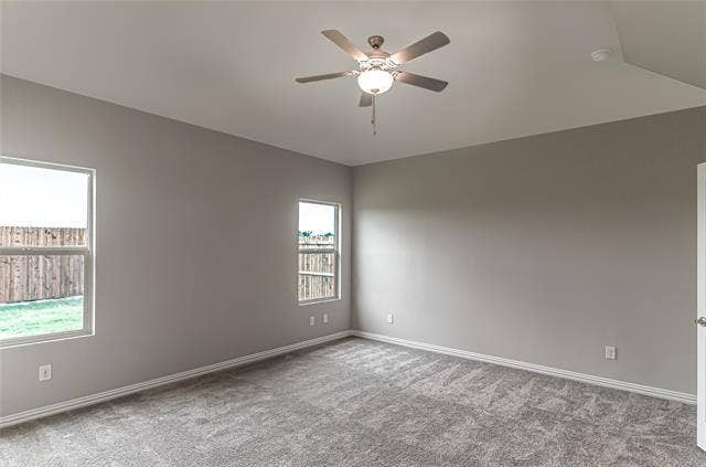448 Ella Lane, Fate, TX 75087 Spacious room featuring vaulted ceilings, a ceiling fan with integrated lighting, two windows, and textured gray carpeting