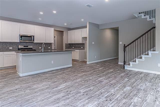 448 Ella Lane, Fate, TX 75087 Open-concept living space with wood-finish flooring extending into the kitchen