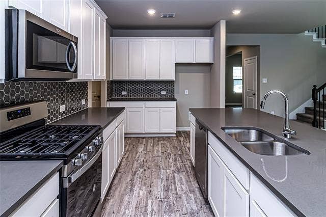 448 Ella Lane, Fate, TX 75087 Modern kitchen featuring a central island with an undermount double-basin sink and gooseneck faucet