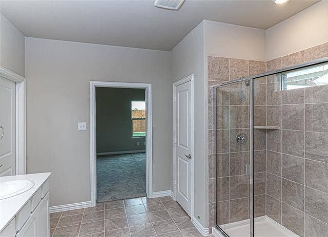 448 Ella Lane, Fate, TX 75087 Shower enclosure featuring clear glass panels, a chrome-finish shower head, and an integrated corner shelf