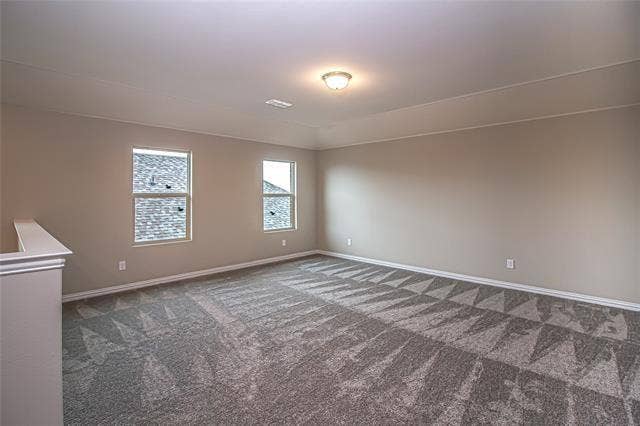 448 Ella Lane, Fate, TX 75087 Spacious room featuring neutral paint, patterned carpeting, white baseboards, and two windows