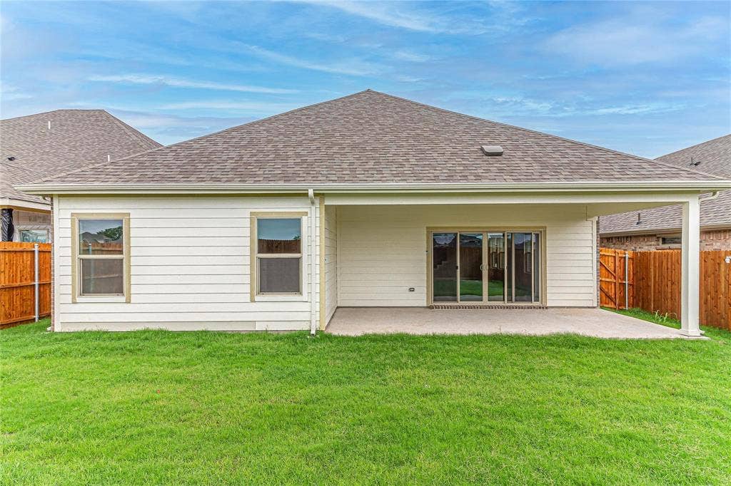 448 Ella Lane, Fate, TX 75087 Rear exterior featuring a covered patio with concrete flooring, a sliding glass door, and white siding