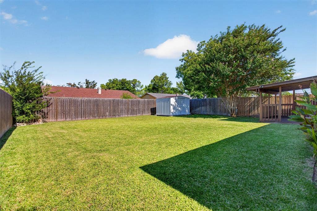 4213 Cheyenne Drive, Rowlett, TX 75088 Large backyard grass area with storage shed.