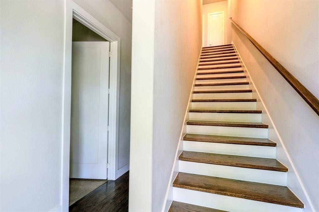 2514 Vintage Street, Farmers Branch, TX 75234 Entryway Staircase featuring wood-finish treads and white risers, complemented by a wood-finish handrail. 1st Floor Bedroom
