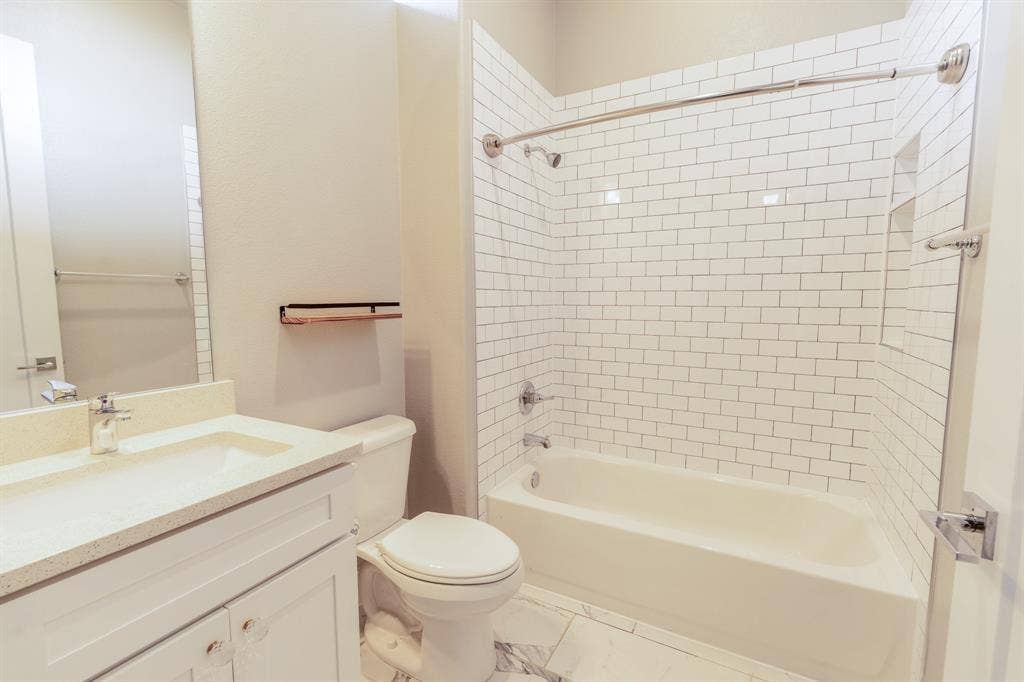 2514 Vintage Street, Farmers Branch, TX 75234 Second bedroom en-suite bathroom with quartz countertop, a white subway tile shower surround and a built-in niche