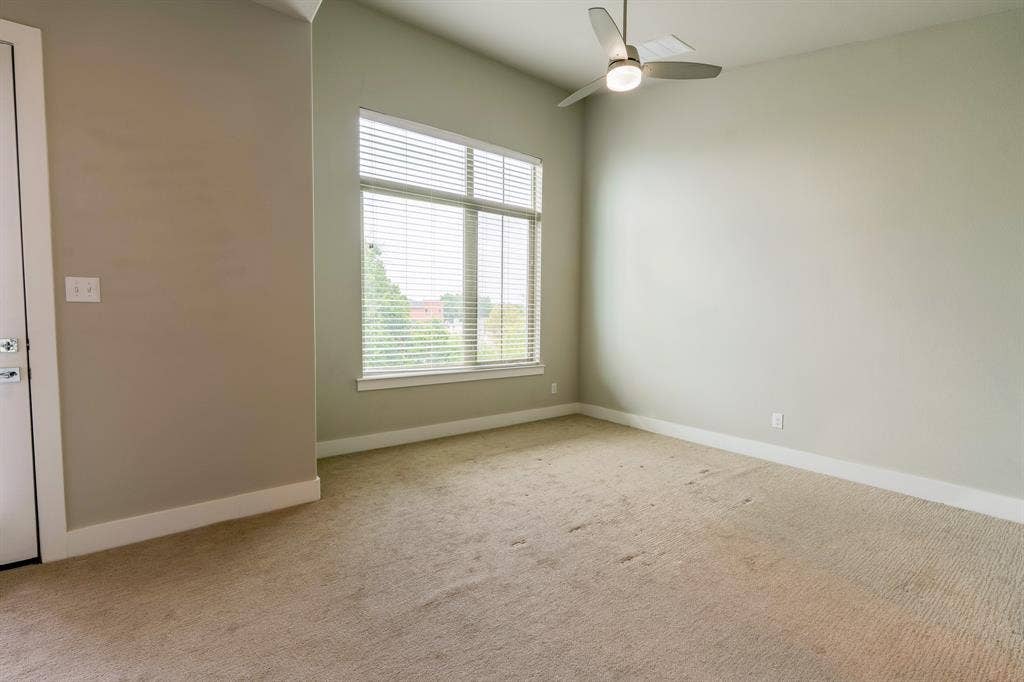 2514 Vintage Street, Farmers Branch, TX 75234 Spacious third floor primary bedroom featuring a large window with blinds, a modern ceiling fan, high vaulted ceilings and light-toned walls