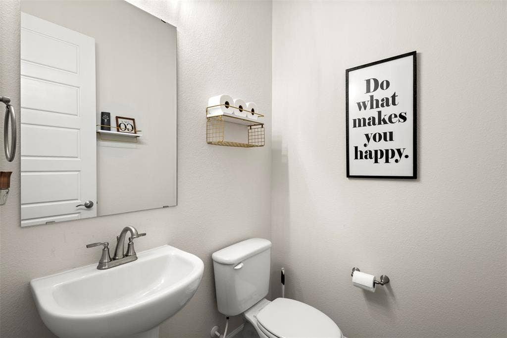 2837 Midlake Drive, Midlothian, TX 76065 Pedestal sink with chrome faucet, a rectangular wall-mounted mirror, and a white paneled door