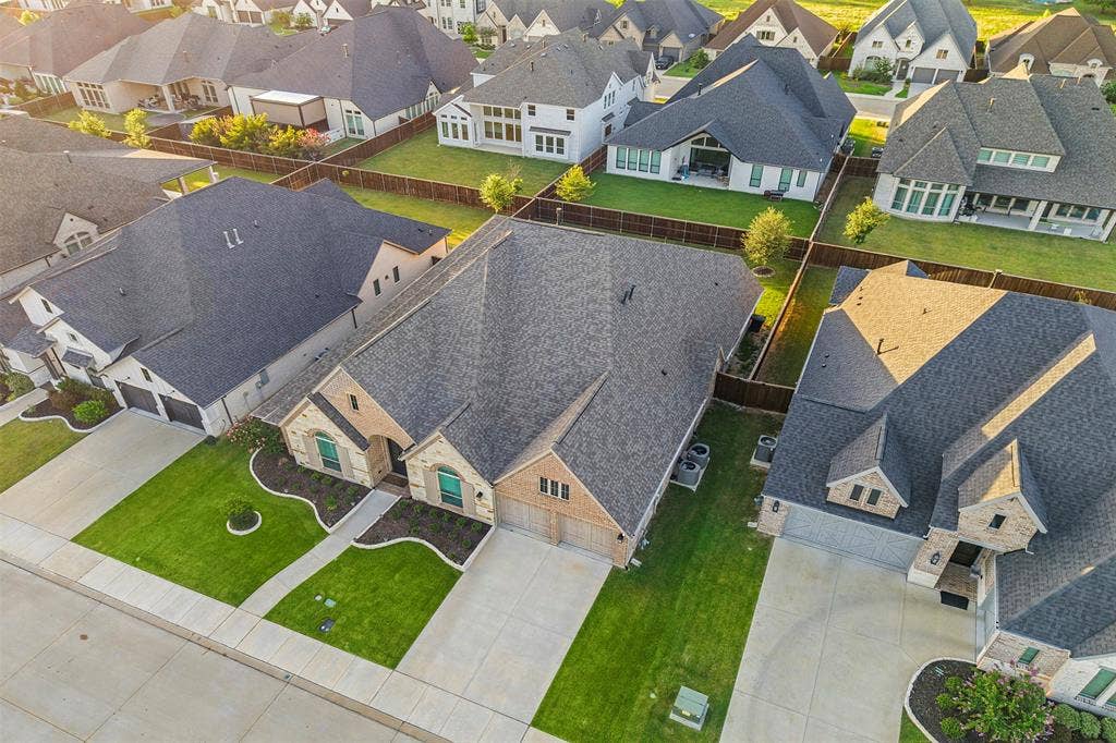 2837 Midlake Drive, Midlothian, TX 76065 Aerial view showcasing a residential property featuring a brick and stone facade, a dark shingle roof, and a two-car garage